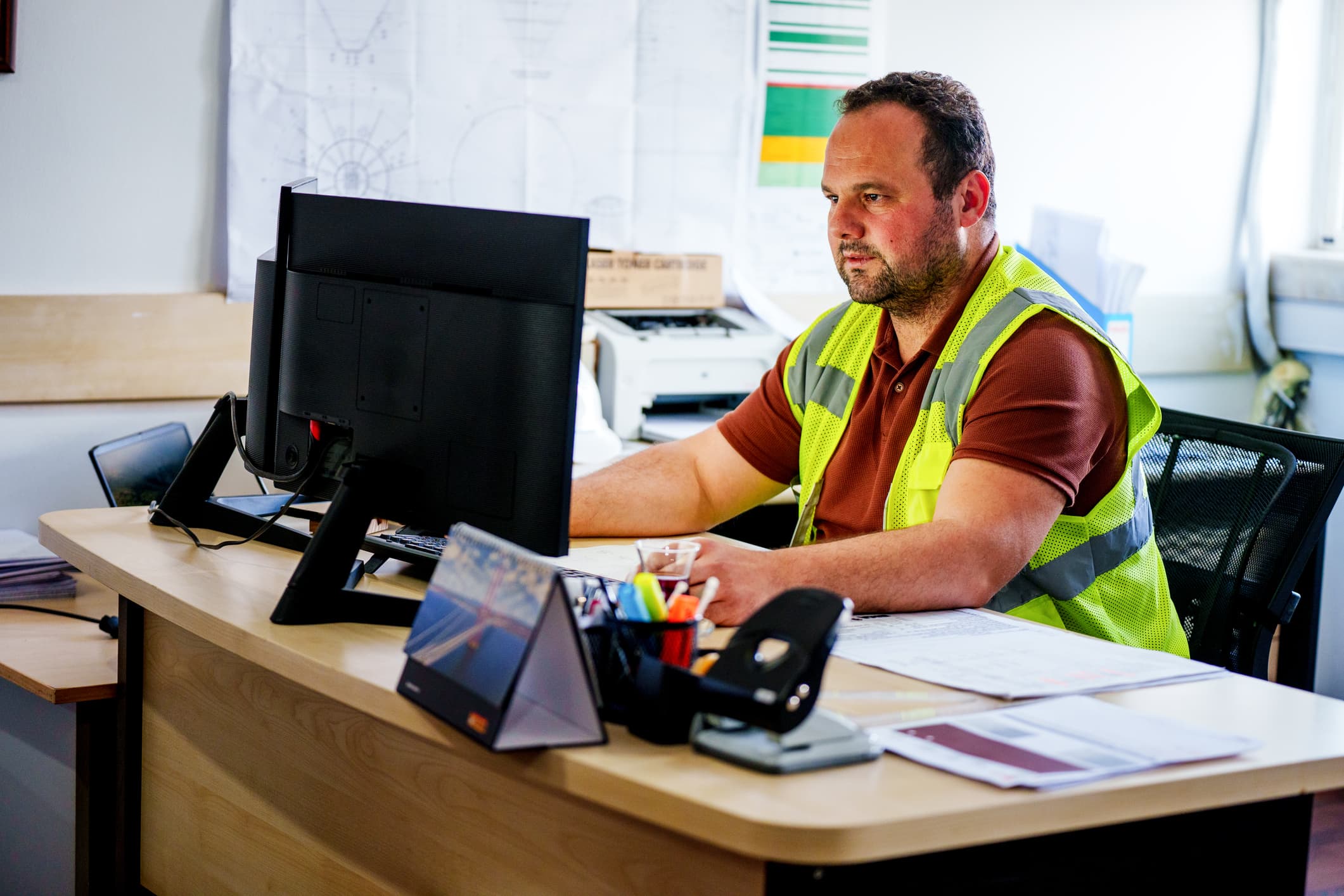 Construction Site Engineer Working at Office Desk on Computer stock photo