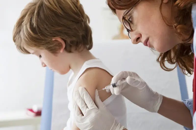 Doctor giving a boy a vaccine