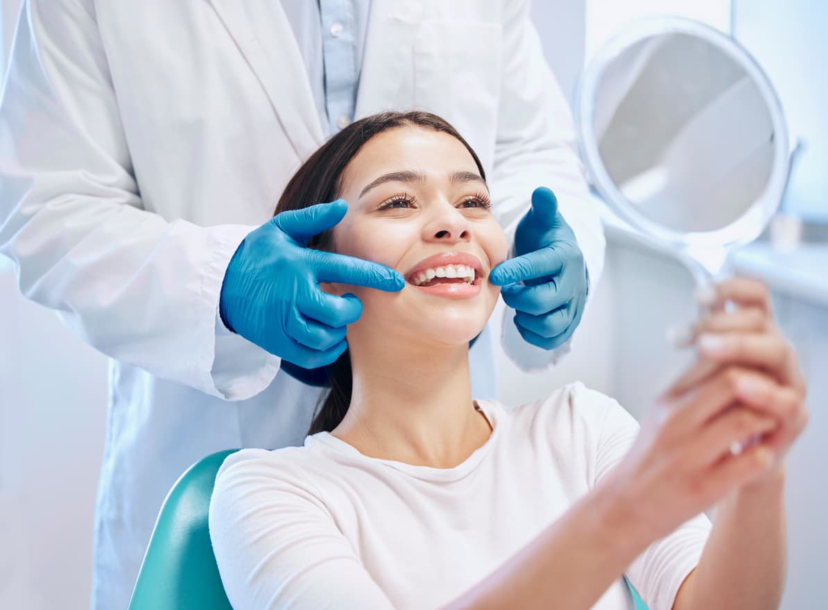 Shot of a young woman checking her results in the dentists office