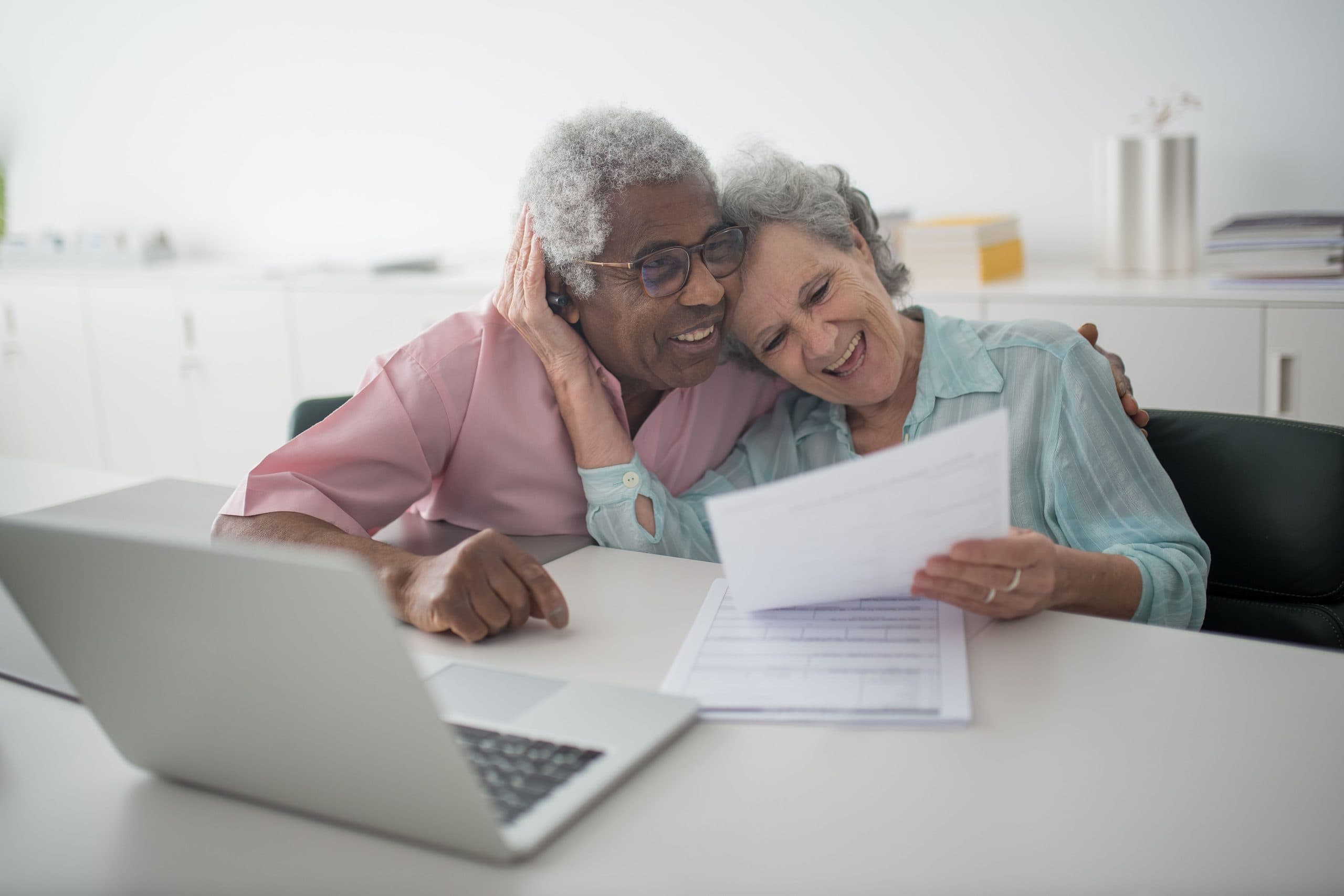 Smiling older couple reviewing a document together