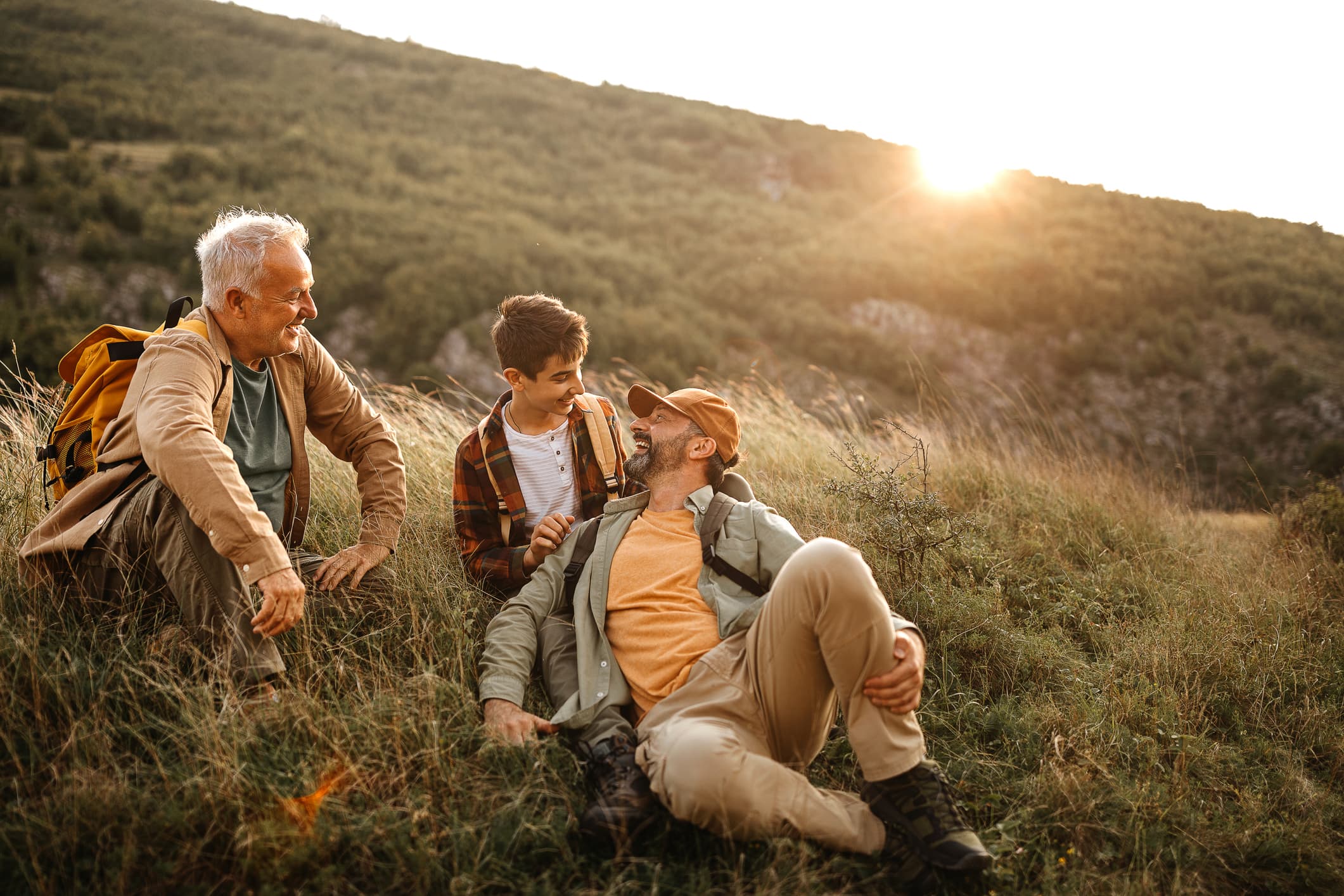 Happy three generations males relaxing on hiking tour stock photo