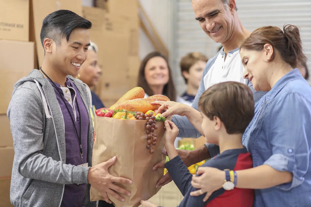 Man giving family a grocery bag