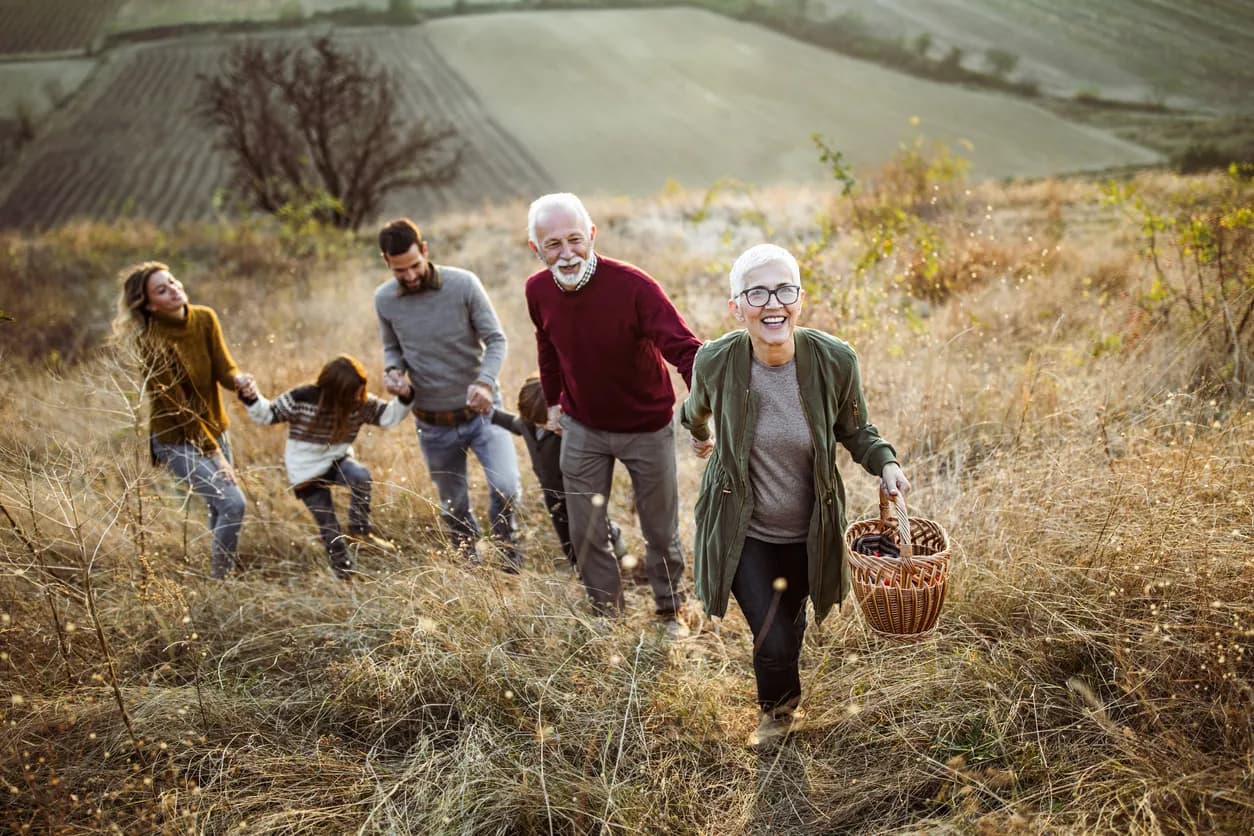 Family walking in a field holding hands