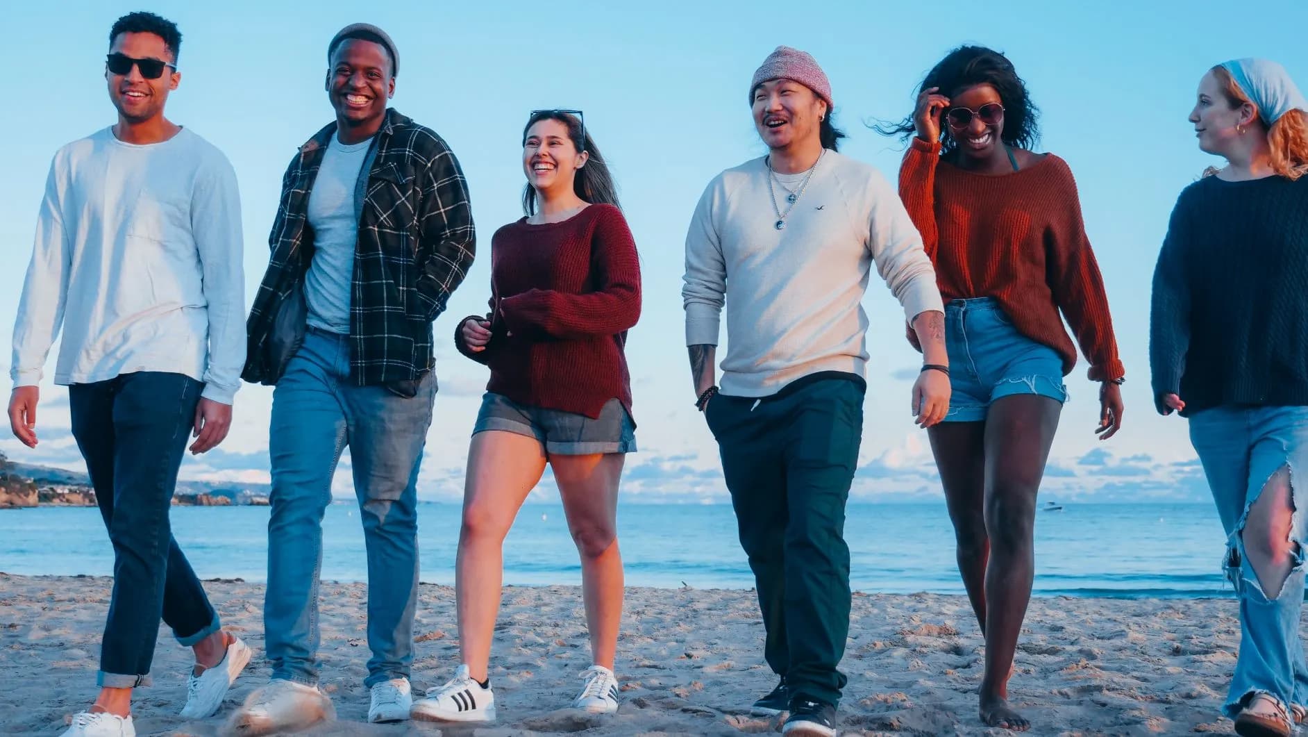 Six people walking on a beach
