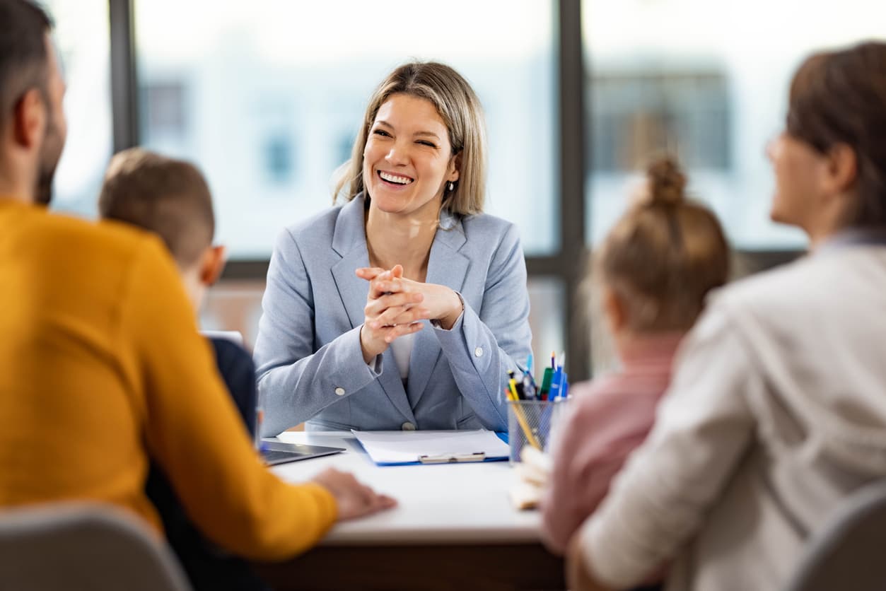 female agent smiling as she speaks to family of clients