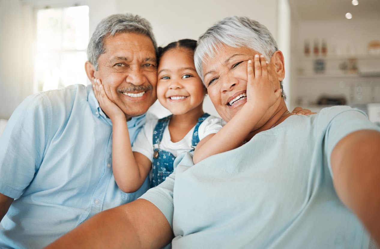 Happy granddaughter smiling between two grandparents