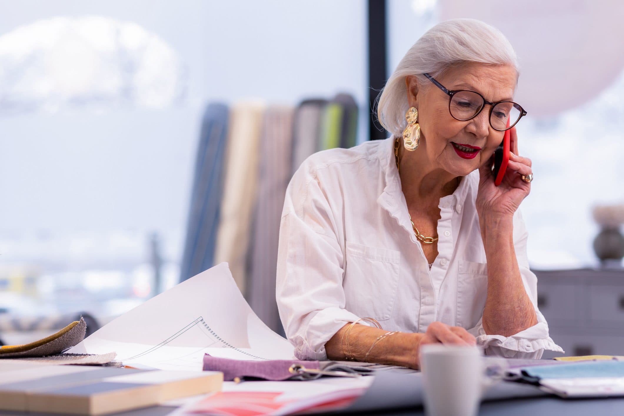 Enchanting well-groomed aging boss speaking on the phone in office