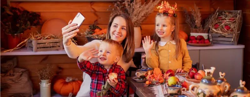 Thanksgiving family waving at smartphone