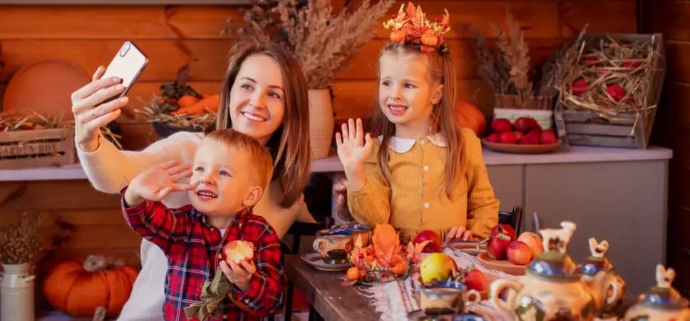Thanksgiving family waving at smartphone