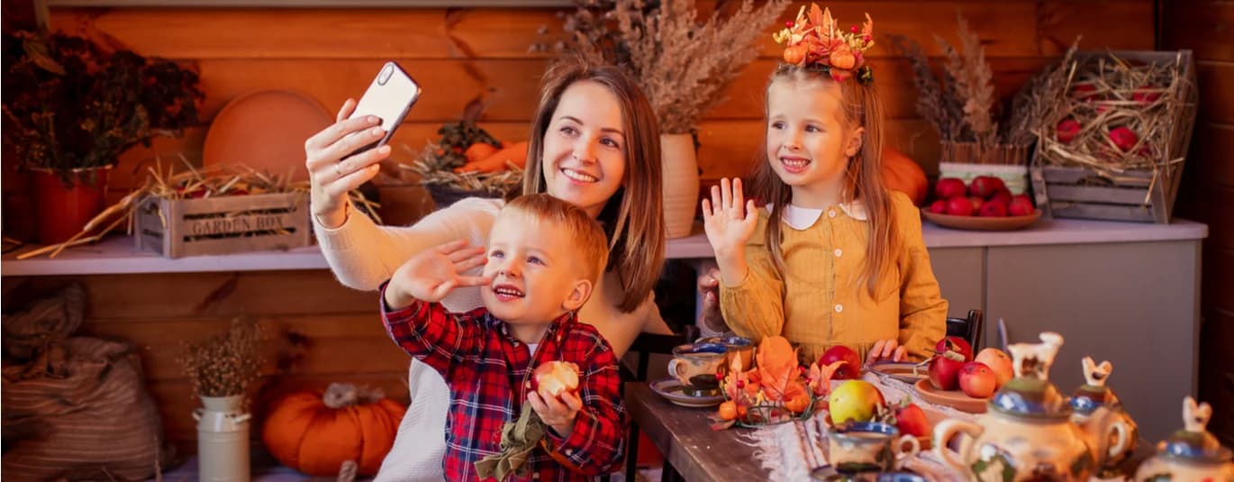 Family smiling and waving at a phone