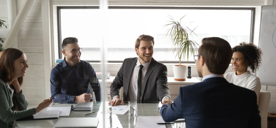 Smiling male business partners shake hands greeting get acquainted at meeting in boardroom, happy businessmen handshake close deal or make agreement after negotiation in office, partnership concept
