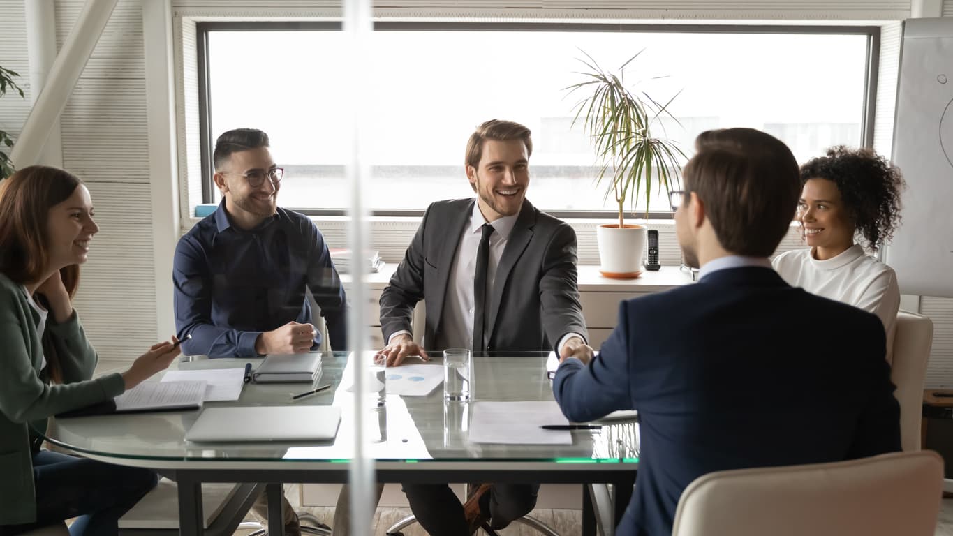 Smiling male business partners shake hands greeting get acquainted at meeting in boardroom, happy businessmen handshake close deal or make agreement after negotiation in office, partnership concept
