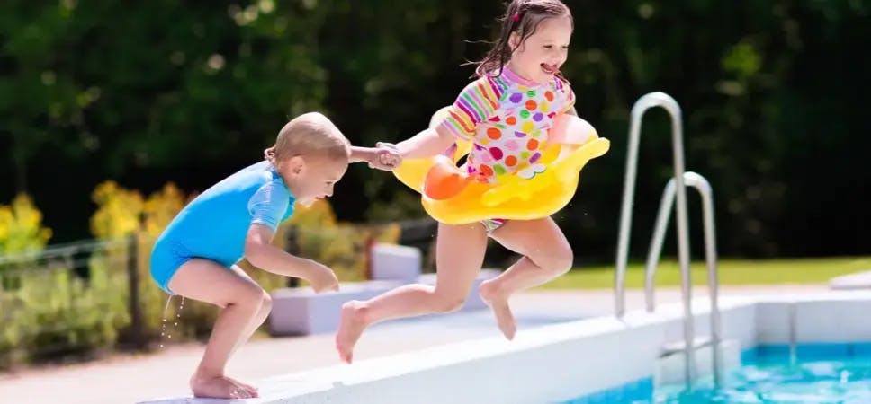Kids jumping into a pool