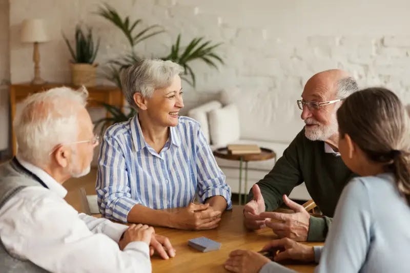 Four older people conversing at a round table