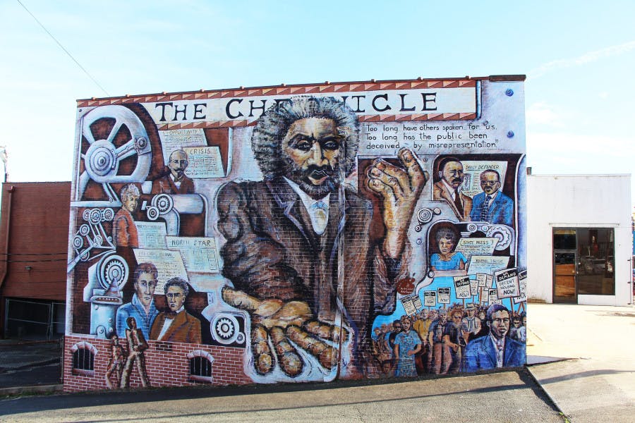 A mural on the side of the Winston-Salem Chronicle building that displays a history of the black press in the United States