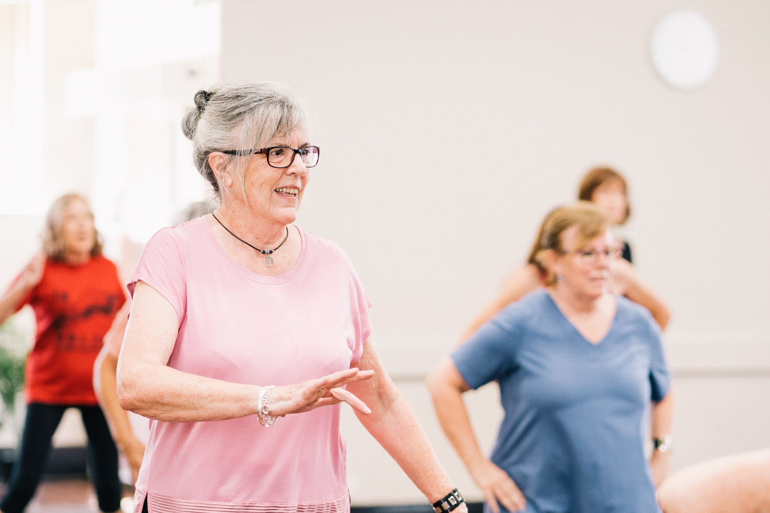 Older woman leading a group exercise class