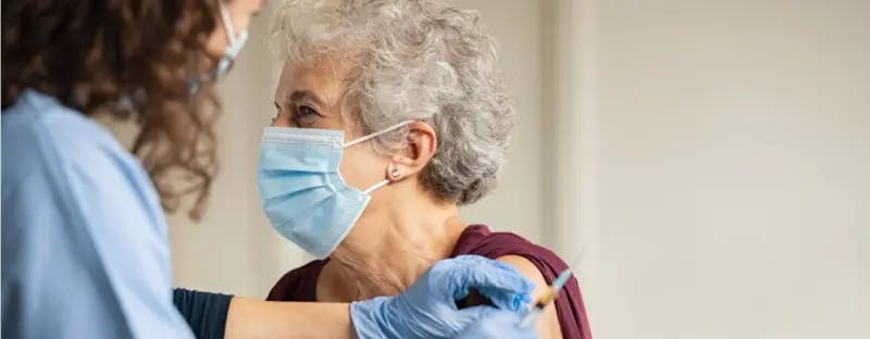 Person wearing a mask getting a vaccine