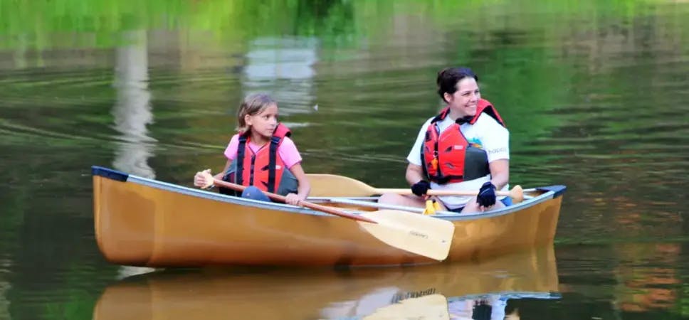 2 kids in a canoe on a lake
