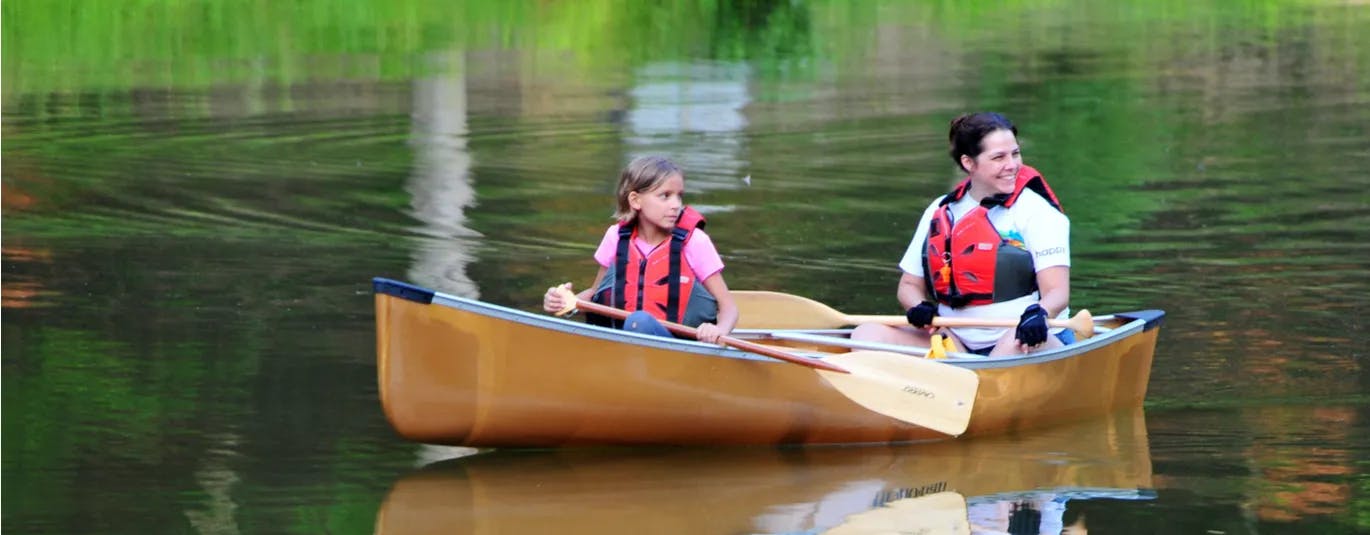 2 kids in a canoe on a lake