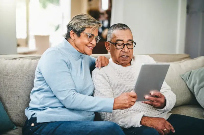 Couple looking at tablet on sofa