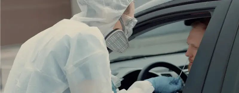Person getting a covid-19 test in a car