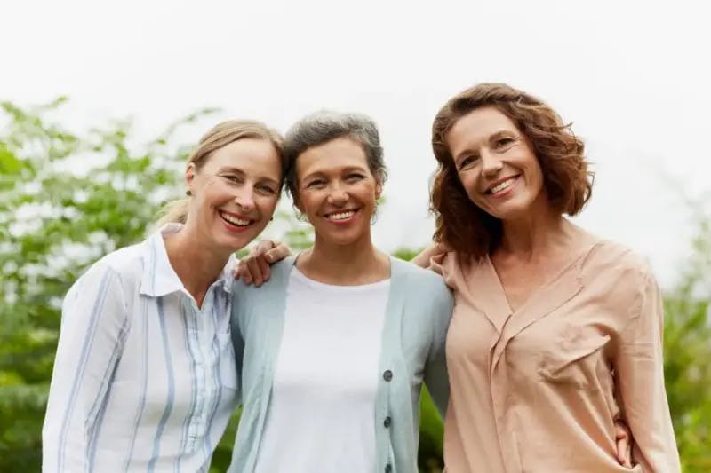 Three women outside smiling at camera