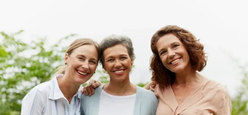 Three women outside smiling at camera