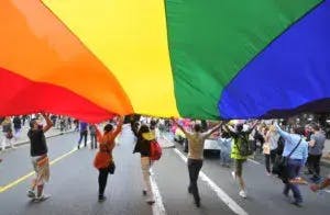 People with a big pride flag in a street